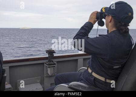 Sul mare del sud della Cina (10 giugno 2017) della Cmdr. Claudine Caluori, comandante della Arleigh Burke-class guidato-missile destroyer USS Sterett (DDG 104) osserva il Giappone marittimo Forza di Autodifesa (JMSDF) nave JS Izumo (DDH 183) Off Sterett del lato di dritta. Sterett, Izumo, nave JMSDF JS Sazanami (DD 113), Royal Canadian navy ship HMCS Winnipeg (338) e Royal Australian navy ship HMAS Ballarat (FFH 155) ha condotto una serie di operazioni marittime insieme nel mare della Cina del Sud. Sterett è parte della superficie Sterett-Dewey Action Group ed è il terzo gruppo di distribuzione che operano sotto il comando e biella Foto Stock