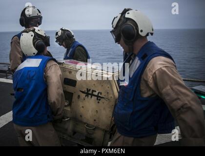 Oceano Pacifico - Marines con il combattimento cargo, xv Marine Expeditionary Unit spostare un generatore dalla nave del ponte di volo durante la Certificazione a bordo della USS Pearl Harbor, Giugno 5, 2017. CERTEX è l ultimo di una serie di esercizi di addestramento, che certifica la MEU-ARG team capace per la distribuzione a sostegno della flotta e i comandanti di combattente per tutta la gamma di operazioni militari. Foto Stock