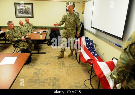 Sgt. 1. Classe David stivali, dall'88Supporto regionale del Comando Operazioni sui sinistri sezione, incarica una notifica di incidenti/Assistenza Officer corso sul modo corretto per la piegatura di una bandiera prima di consegnarlo a un soldato della famiglia, 9 Giugno all'88RSC sede sulla Fort McCoy, Wisconsin. Foto Stock