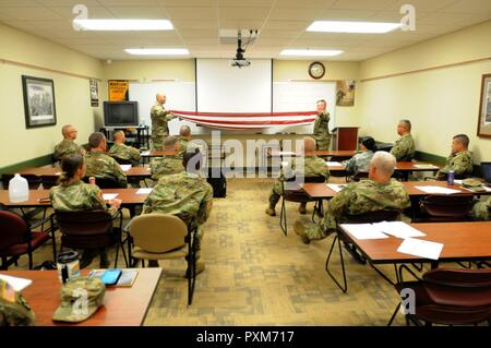 Sgt. 1. Classe David stivali e Sgt. Ronald Aulet, sia dall'88sostegno regionale del comando Casualty sezione operazioni, richiedere una notifica di incidenti/Assistenza Officer corso sul modo corretto per la piegatura di una bandiera prima di consegnarlo a un soldato della famiglia, 9 Giugno all'88RSC sede sulla Fort McCoy, Wisconsin. Foto Stock