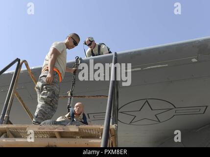 Stati Uniti Air Force Airman 1. Classe Giacobbe Trimble, orientamento e di controllo tecnico, fissata una caduta del sistema di ritenuta per l'ala di un C-17 Globemaster III per sospendere un manichino di formazione dall'ala in modo da simulare una caduta accidentale durante un esercizio di Al Udeid Air Base, Qatar, Giugno 6, 2017. Il dispositivo di protezione anticaduta esercizio è stata condotta dai membri del 8° Expeditionary aria squadrone di mobilità a sostegno della protezione anticaduta mese di sensibilizzazione ed è stato progettato per testare il 8 EAMS' fall protection piano di salvataggio. Foto Stock