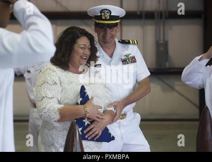 NORFOLK (Giugno 8, 2017) - Lt. La Cmdr. Gregorio Curl passeggiate da sua moglie Christina Curl, attraverso il lato ragazzi come lui è rediretto a terra per l'ultima volta durante il suo pensionamento cerimonia presso il centro di aviazione navale addestramento tecnico unità sulla stazione navale di Norfolk. Curl ultimo è servita come assistenza aeromobili officer a bordo della portaerei USS George Washington (CVN 73). Foto Stock