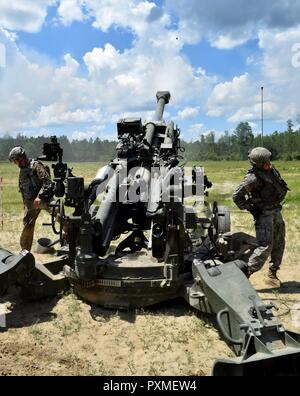 Il sergente Mark Yacono e Sgt. Justin Calder della batteria C, 1° Battaglione, 118a Campo Reggimento di Artiglieria fire a 155 mm proiettile da loro M777 Obice durante un'esercitazione a fuoco a Fort Stewart. Il 118A fa ed altre unità di Macon-basato 48th della brigata di fanteria combattere Team stanno conducendo un esportabili combattere la capacità di formazione di rotazione in partenariato con la terza divisione di fanteria. Foto Stock