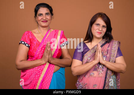 Due indiani donna che indossa abiti tradizionali saluto Foto Stock