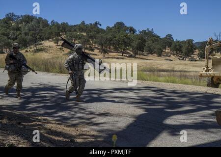 Stati Uniti Pfc dell'esercito. Bryan Baradji, 822nd distacco di trasporto al di fuori del Brockton, Massachusetts, porta una lettiera per un pronto soccorso per un improvvisato dispositivo esplosivo (IED) simulazione su Fort Hunter Liggett, la California il 15 giugno 2017. La simulazione è stata una parte del 91Divisione Formazione guerriero dell esercizio (WAREX) 91-17-03, un collettivo di piattaforma di formazione per generare in grado, letale e lottare contro le forze di pronto. È importante che tutti gli aspetti della formazione come vicino al realistico possibile, compreso il trasporto dei soldati feriti. Foto Stock