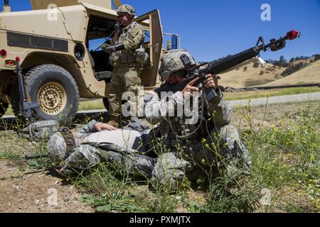 Stati Uniti Il personale dell'esercito Sgt. Tim Walsh, 822nd distacco di trasporto al di fuori del Brockton, Massachusetts, fornisce la sicurezza per un incidente in un improvvisato dispositivo esplosivo (IED) formazione sulla Fort Hunter Liggett, la California il 15 giugno 2017. IED formazione fa parte della 91a Divisione di formazione era il Guerriero Esercizio (WAREX) 91-17-03, un collettivo di piattaforma di formazione che prepara i soldati per combattere immergendoli in realistici scenari di combattimento; qui, Walsh può essere completamente preparati in caso di un vero e proprio attacco di IED. Foto Stock