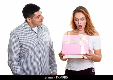 I giovani ispanici matura in amore con la donna apertura scatola regalo cercando sorpreso Foto Stock