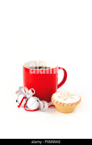 Red mug riempito di caffè nero ,decorate con il bianco Jingle Bells, argento nastro metallico e un pasticcio di carne macinata su sfondo bianco. Foto Stock