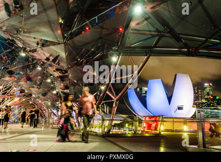 Persone su Helix Bridge, illuminato passerella pedonale a Singapore il Marina Bay. Foto Stock