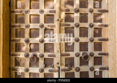 In prossimità di una porta di legno con architettura carving, nel deserto città di Jaisalmer in India Foto Stock