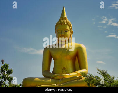 Un Dorato statua del Buddha in Thailandia con il blu del cielo in background Foto Stock