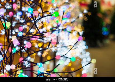 Close up colorate luci lampadina a forma di albero garland sullo sfondo di vari incandescente le luci di Natale nel negozio. Sfondo di vacanza. Vacanze di Natale Foto Stock