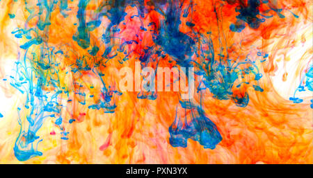 Inchiostro blu dye nuvole la miscelazione dietro uno sfondo colorato Foto Stock