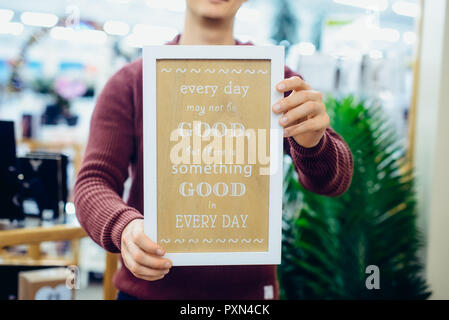 Uomo caucasico le mani dell azienda messaggio motivazionale digitando sulla tavola di legno. Ogni giorno le citazioni ispiratrici concetto. In stile vintage tonificante. Close up, Foto Stock