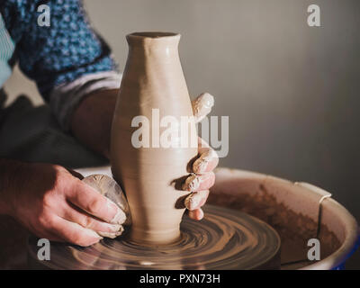 Creazione di terracotta e ceramica tradizionale concetto. Maschio esperto potter mani creando splendide prodotto di creta - vaso - utilizzando lo strumento professionale Foto Stock