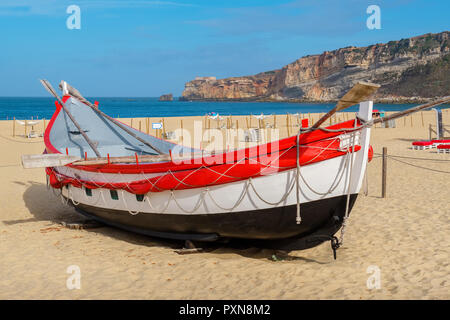 Portoghese tradizionale barca da pesca sulla spiaggia. Nazare, Portogallo Foto Stock