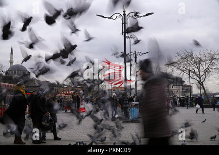 Istanbul, Turchia - 19 Febbraio 2018 : molte persone turche sono passando lontano dalla piazza Eminonu. Un gregge sfocate di piccioni sono battenti. Foto Stock