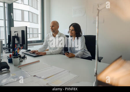 Imprenditore e la donna che lavorano insieme in ufficio Foto Stock