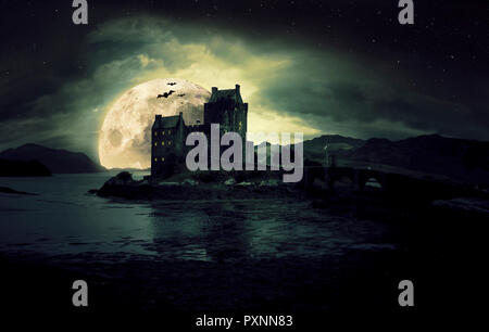 Haunted mystic eerie Eilean Donan Castle in Scozia con il mare intorno ad esso le nuvole scure la luna e mazze per Halloween Foto Stock