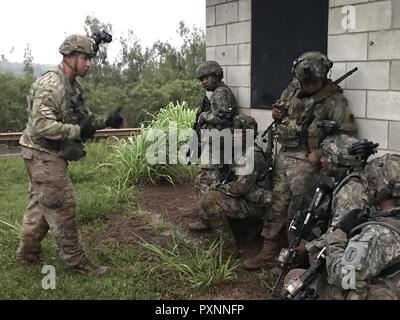 La riserva di esercito di soldati della società Eco, centesimo battaglione, 442nd Reggimento di Fanteria riceve istruzioni da un osservatore/Controller (OC) della 196th della brigata di fanteria (supporto di formazione brigata) durante l'esercizio fucina di lava, a Kahuku Area Formazione, Hawaii. Foto Stock