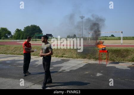 Ispettore antincendio Andy Daie e Carl Sauvage, assegnato a U.S. Army Garrison Benelux' Dipartimento di servizi di emergenza, spiegare come arrestare un grasso incendio in una cucina durante la giornata di sicurezza, Wingene Air Base, Belgio, 01 giugno 2017. Foto Stock