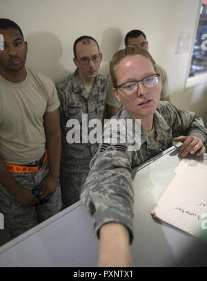 Stati Uniti Air Force Staff Sgt. Courtnee Hummel, un passeggero agente di servizio con il 8° Expeditionary Aria Mobilità squadrone oggetti schermate sul monitor Al Udeid Air Base, Qatar, 14 giugno 2017. Hummel è aiutare i suoi compagni aviatori testare le loro conoscenze sui più recenti precauzioni di sicurezza per ispezionare il bagaglio personale che passano attraverso il terminal passeggeri. Foto Stock