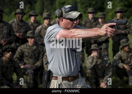 Un istruttore con Marine Corps Embassy Security Group (MCESG) dimostra la corretta gestione delle armi della M9 pistola sul Marine Corps base Quantico, Va., 15 giugno 2017. La missione di MCESG è di fornire protezione al personale della missione e impedire la compromissione della sicurezza nazionale le informazioni e le attrezzature al designato diplomatico consolare e strutture. Foto Stock