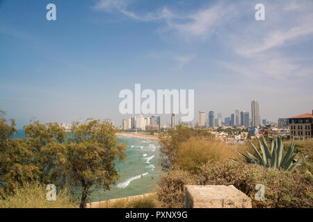 Moderno skyline della città di Tel Aviv, Israele, visto dalla città vecchia in una calda giornata estiva, persone nuotare nel mare. Foto Stock