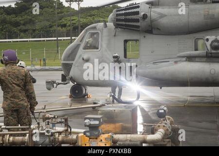 Gli ICM FUTENMA, Okinawa, in Giappone- Staff Sgt. Jahbari H. codici, centro, refuels un CH-53E Super Stallion elicottero Giugno 16 su Marine Corps Air Station Futenma Okinawa, in Giappone. CH-53E è il più grande e più pesante in elicottero militare degli Stati Uniti. Marines usa questi elicotteri per fornire truppe, i veicoli e le forniture provenienti da navi a riva. Codici è un'attività aeronautica chief con Marine elicottero pesante Squadron 462, terzo aeromobile Marina Wing, attualmente assegnato al primo velivolo Marina Wing sotto l'unità programma di installazione. Foto Stock