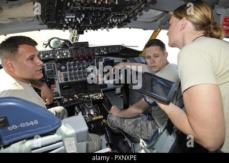 Tech. Sgt John Kerschenheiter e Crystal Guetschow, insieme con il personale Sgt. Alex Bastow, eseguire operazioni di manutenzione all'interno del cockpit di un KC-135 Stratotanker sulla linea di volo a Selfridge Air National Guard Base, Mich, giu 11, 2017. I tre aviatori a lavorare insieme come una singola unità, il caricamento di software per l'aeromobile centrali del modulo di elaborazione. Foto Stock