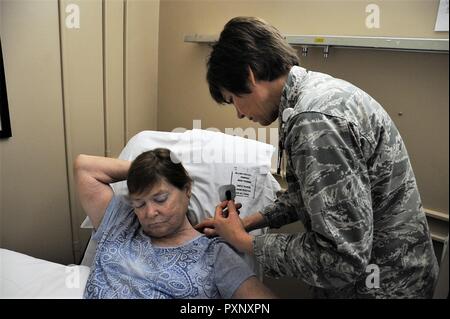 Lt. Col Candy Wilson (destra), 779th gruppo medico di infermiera, luoghi di un nervo elettrodo Scrambler pollici di distanza dalla fonte di dolore neuropatico sul retro di un collo del paziente 30 Maggio 2017 a base comune Andrews, Md. un altro elettrodo sarà collocato sul piede del paziente dove si sente alcun dolore. La bassa corrente elettrica che passa attraverso gli elettrodi a Grays corpo provoca un "nessun dolore" segnale di ignorare il dolore esistente per il segnale inviato al cervello del paziente. Foto Stock