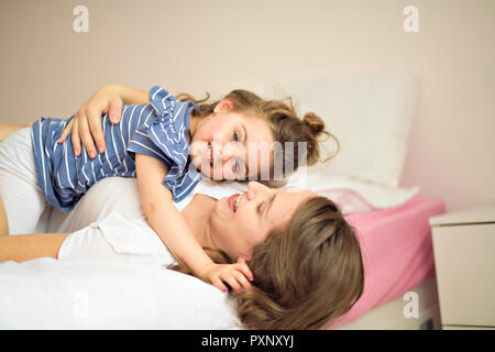 Madre e figlia godono nel letto di casa Foto Stock