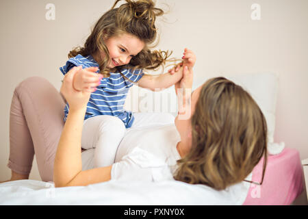 Madre e figlia godono nel letto di casa Foto Stock