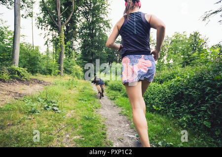 Trail Running athletic donna nella foresta verde, sport ispirazione e motivazione. Sentiero femmina runner cross country in esecuzione. Concetto di fitness all'aperto ho Foto Stock