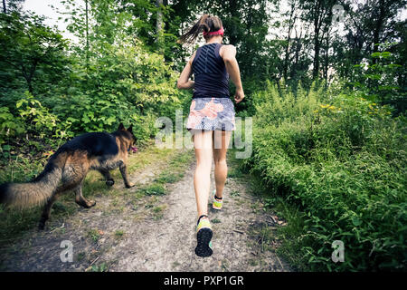 Trail Running athletic donna nella foresta verde, sport ispirazione e motivazione. Sentiero femmina runner cross country in esecuzione. Concetto di fitness all'aperto ho Foto Stock