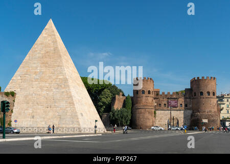 La Piramide Cestia e Porta San Paolo, uno dei cancelli meridionale nelle Mura Aureliane, nel quartiere Ostiense, Roma, Italia. Foto Stock