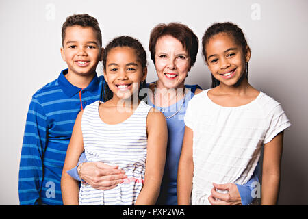 Nero a due gemelle e il bambino con la nonna in studio lo sfondo bianco Foto Stock