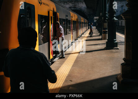 Le persone entrano in treno in stazione ferroviaria sul giorno di estate, Portogallo Foto Stock
