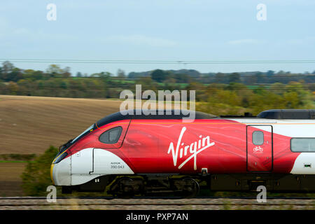 Treni del Virgin Pendolino treno elettrico, vista laterale in velocità, Warwickshire, Regno Unito Foto Stock