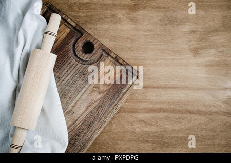 Cucina Background: matterello con carta asciugatutto o tovagliolo sulla tavola di legno sopra la tavola in legno rustico. Vista da sopra con lo spazio di copia Foto Stock