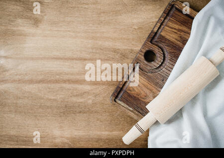 Cucina Background: matterello con carta asciugatutto o tovagliolo sulla tavola di legno sopra la tavola in legno rustico. Vista da sopra con lo spazio di copia Foto Stock