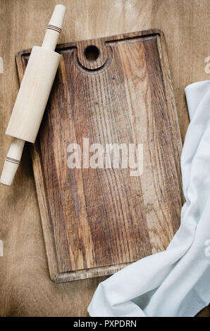 Cucina Background: matterello con carta asciugatutto o tovagliolo sulla tavola di legno sopra la tavola in legno rustico. Vista da sopra con lo spazio di copia Foto Stock