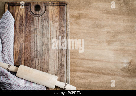 Cucina Background: matterello con carta asciugatutto o tovagliolo sulla tavola di legno sopra la tavola in legno rustico. Vista da sopra con lo spazio di copia Foto Stock