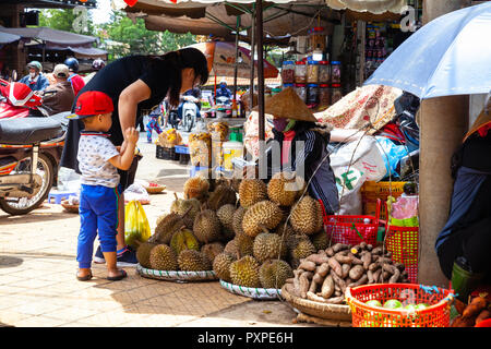 DA LAT, VIETNAM - 23 settembre: una donna vietnamita con un bambino acquista durian sulla strada del mercato il 23 settembre 2018 in Da Lat, Vietnam. Foto Stock