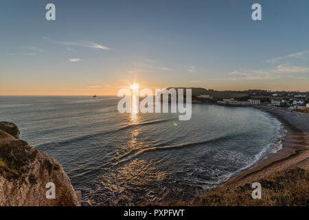 Tramonto d'acqua dolce. Un tramonto autunnale con un sole scaletta tra le feste di addio al celibato e Mermaid Rocksat acqua dolce, Isola di Wight Foto Stock