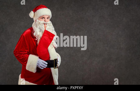Felice divertente Babbo Natale con la calza rossa sullo sfondo. Foto Stock