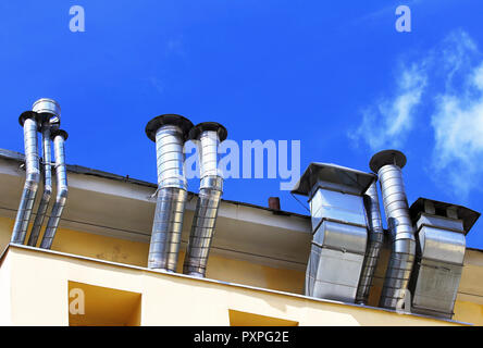 Tubi di ventilazione e gli attuatori sul tetto di un edificio Foto Stock
