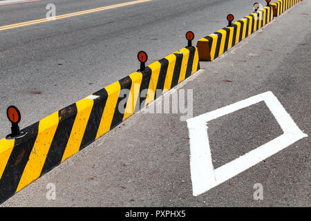 I blocchi di calcestruzzo con cautela striped pattern, strada costruzione di recinzione Foto Stock