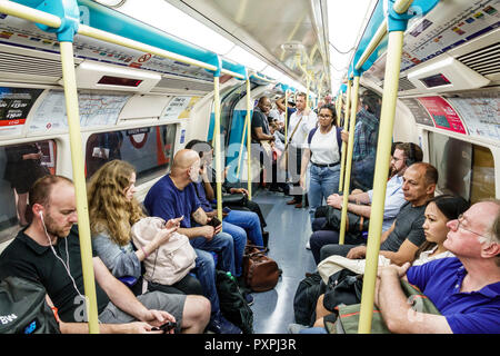 Londra Inghilterra,UK,metropolitana metropolitana metropolitana, treno,carrozza,interno,pendolari,passeggeri passeggeri motociclisti,uomo uomo uomo maschio,donna donna donna donna donna,B Foto Stock