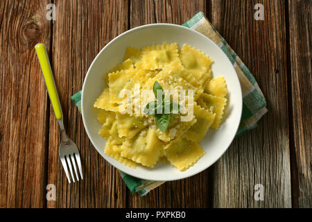 Ravioli ripieni di spinaci e ricotta con formaggio e basilico - cibo italiano - primo piano Foto Stock